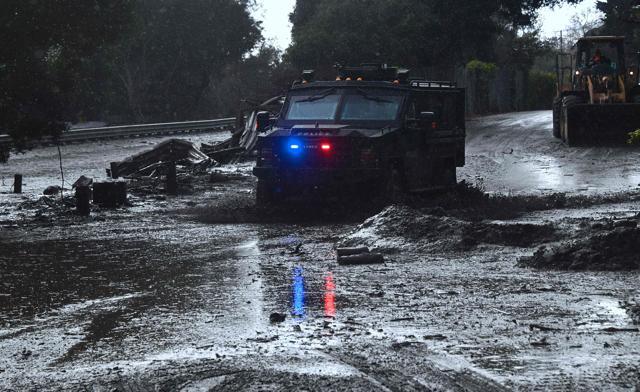 A police vehicle drives across a flooded side road off the US 101 freeway near the San Ysidro exit in Montecito, California on January 9, 2018. (AFP Photo) A police vehicle drives across a flooded side road off the US 101 freeway near the San Ysidro exit in Montecito, California on January 9, 2018. (AFP Photo)