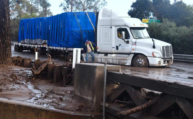 Driver Gabriel Panduro steps out of his truck stuck in the mud since early morning when mud brought it to a standstill along a flooded US 101 freeway near the San Ysidro exit in Montecito, California on January 9, 2018. (AFP Photo) Driver Gabriel Panduro steps out of his truck stuck in the mud since early morning when mud brought it to a standstill along a flooded US 101 freeway near the San Ysidro exit in Montecito, California on January 9, 2018. (AFP Photo)