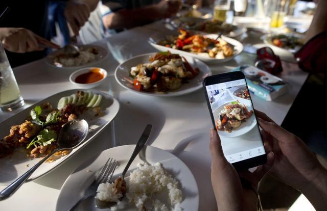 A customer takes photos of food cooked by Jay Fai. (AP) A customer takes photos of food cooked by Jay Fai. (AP)