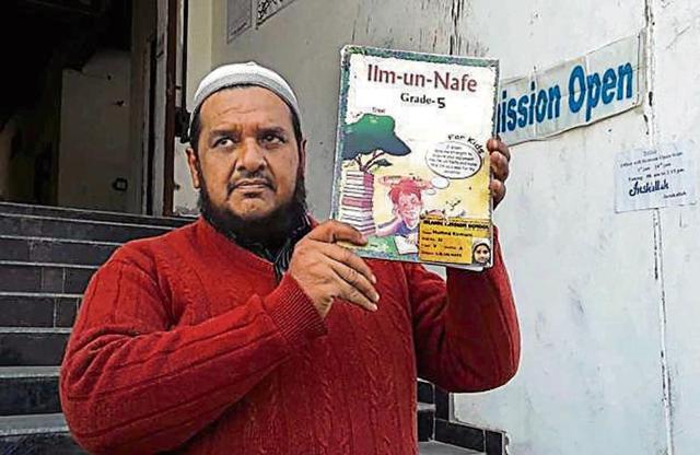 A member of school management Suhail Ahmad holding a copy of the book ‘Ilm-un-Nafe’. (HT Photo/Mahipal Singh )