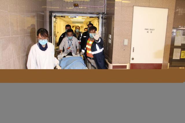 This handout from Apple Daily shows a murder suspect accused of killing women and boy at the Ritz-Carlton, arriving on a gurney at the Queen Elizabeth Hospital under police escort in Hong Kong. (AFP Photo)