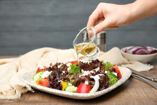 Apple cider vinegar being added to a salad. (Shutterstock)
