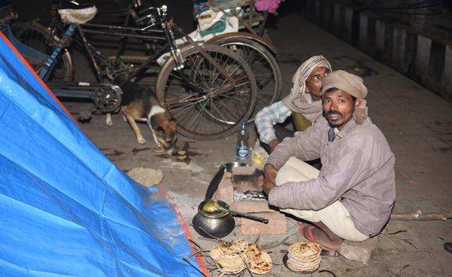 Rickshaw pullers preparing their ‘roti-daal’ dinner at a pavement. (Subhankar Chakraborty/HT Photo) Rickshaw pullers preparing their ‘roti-daal’ dinner at a pavement. (Subhankar Chakraborty/HT Photo)