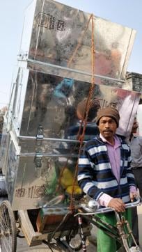 A rickshaw puller brings five tin boxes in which the seized money would be kept and sealed. (HT Photo)