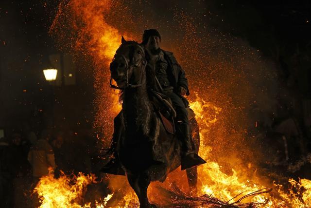 On the eve of Saint Anthony's Day, dozens ride their horses through the narrow cobblestone streets of the small village of San Bartolome. (AP)