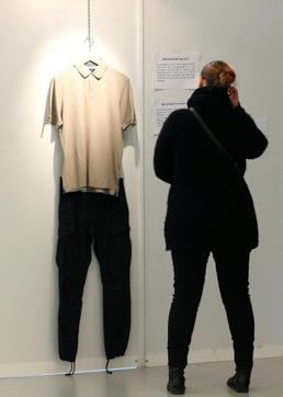A woman watches male clothes at the exhibition "What Were You Wearing?" that showcases the stories of U.S. student rape victims. (REUTERS)