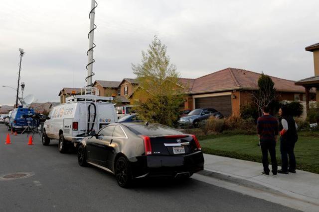 Neighbours stand and watch news crews outside the home of David Allen and Louise Anna Turpin in Perris, California. (Reuters)