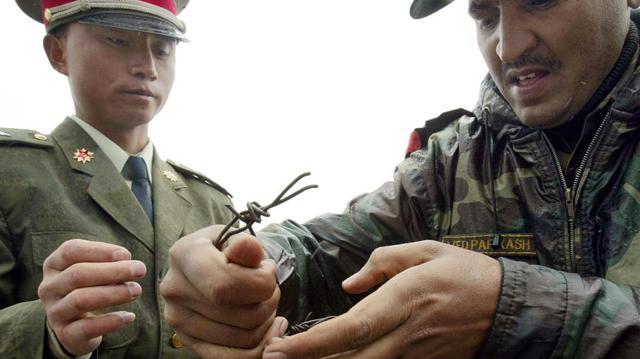 A file photo taken on July 5, 2006 shows a Chinese soldier and an Indian soldier placing a barbed wire fence following a meeting of military representatives at the Nathu La border crossing in Sikkim. (AFP)
