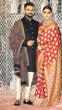 Virat Kohli and Anushka Sharma at their wedding reception in Delhi. Like all her wedding ensembles, the red Banarasi designed by Sabyasachi also became a talking point. (Manoj Verma/HT PHOTO) Virat Kohli and Anushka Sharma at their wedding reception in Delhi. Like all her wedding ensembles, the red Banarasi designed by Sabyasachi also became a talking point. (Manoj Verma/HT PHOTO)