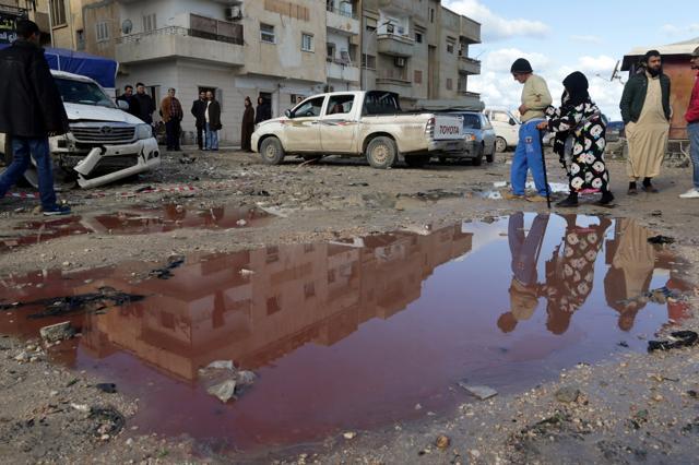 People walk near a puddle of water mixed with blood at the site of twin car bombs in Benghazi. (REUTERS) People walk near a puddle of water mixed with blood at the site of twin car bombs in Benghazi. (REUTERS)