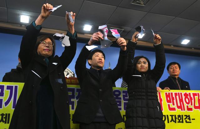 North Koreans who defected to the South tear pictures of North Korean leader Kim Jong-Un during a press conference against the North's attendance at the Pyeongchang Olympics, at the National Assembly in Seoul on January 24, 2018. (AFP Photo) North Koreans who defected to the South tear pictures of North Korean leader Kim Jong-Un during a press conference against the North's attendance at the Pyeongchang Olympics, at the National Assembly in Seoul on January 24, 2018. (AFP Photo)