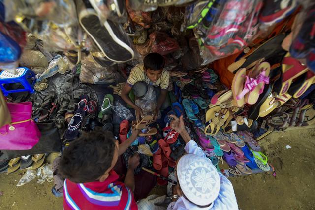 Rohingya refugees buy shoes at Balukhali refugee camp in Bangladesh's Ukhia district on January 24, 2018. The repatriation of hundreds of thousands of Rohingya who fled violence in Myanmar will not begin as planned, Bangladesh said as authorities admitted "a lot of preparation" was still needed. (AFP)