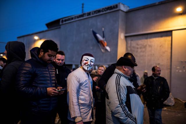 A prison officer wears an Anonymous mask during a protest in front of the Lyon Corbas prison as part of a nationwide movement by prison staff calling for better safety and wages on January 25, 2018. (AFP) A prison officer wears an Anonymous mask during a protest in front of the Lyon Corbas prison as part of a nationwide movement by prison staff calling for better safety and wages on January 25, 2018. (AFP)