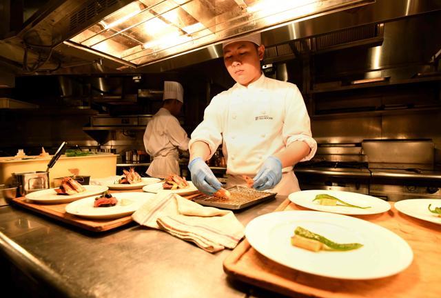 Chefs prepare dishes during lunchtime at the Brasserie Paul Bocuse Le Musee. (AFP) Chefs prepare dishes during lunchtime at the Brasserie Paul Bocuse Le Musee. (AFP)