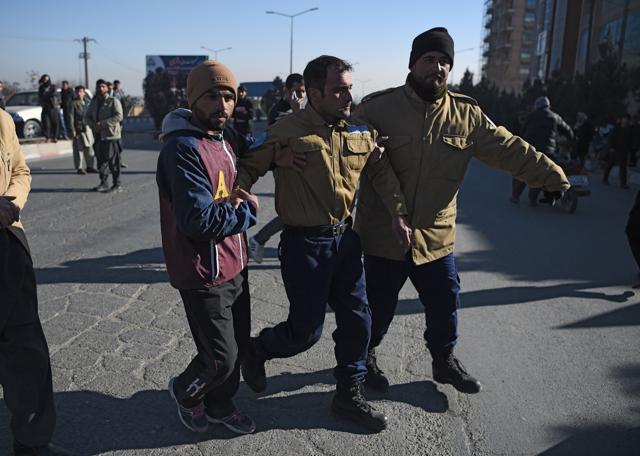 This file photo taken on January 21 shows Afghan security from a private company assisting an injured colleague near the Intercontinental Hotel following an attack by gunmen in Kabul. (AFP) This file photo taken on January 21 shows Afghan security from a private company assisting an injured colleague near the Intercontinental Hotel following an attack by gunmen in Kabul. (AFP)