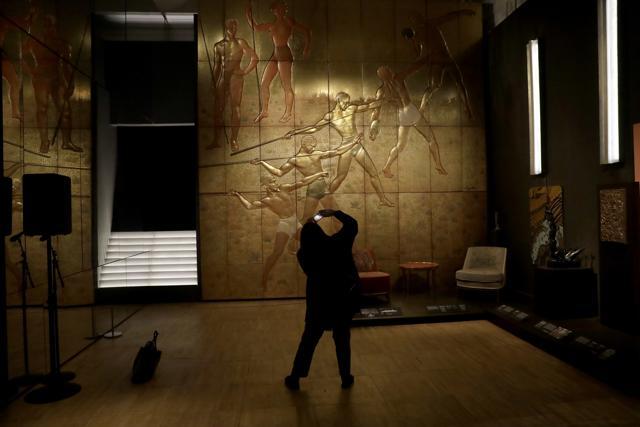 A woman photographs a 1935 golden lacquer panel from the first-class smoking room of the Normandie Les Sports French ocean liner. (AP) A woman photographs a 1935 golden lacquer panel from the first-class smoking room of the Normandie Les Sports French ocean liner. (AP)