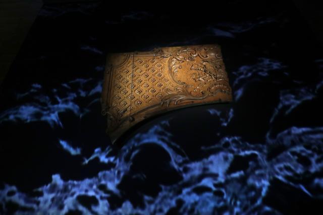 Wave-style lighting surrounds a wooden panel fragment from an overdoor in the first-class lounge on the Titanic that was found floating on the surface of the Atlantic Ocean and is the largest remaining fragment from the ship after it sank on April 14, 1912. (AP) Wave-style lighting surrounds a wooden panel fragment from an overdoor in the first-class lounge on the Titanic that was found floating on the surface of the Atlantic Ocean and is the largest remaining fragment from the ship after it sank on April 14, 1912. (AP)