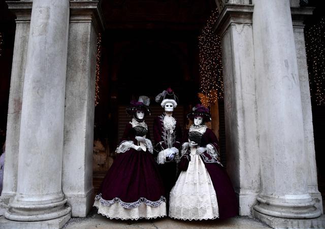 Masked people wearing traditional carnival costumes pose in Saint Mark Square in Venice. (AFP) Masked people wearing traditional carnival costumes pose in Saint Mark Square in Venice. (AFP)