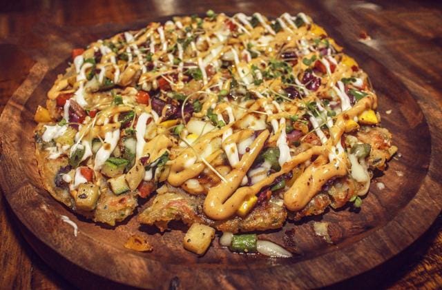 Tonkatsu pizza is made with the dough of tempura flour and veggies. Tonkatsu pizza is made with the dough of tempura flour and veggies.
