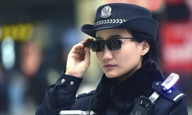 A Chinese police officer using the new hi-tech glasses equipped with facial recognition technology. (Courtesy: Qq.com)