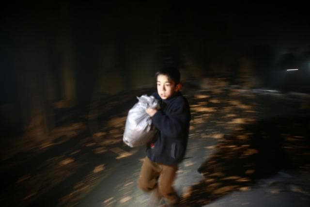 A boy is seen running after an air raid in the besieged town of Douma in eastern Ghouta in Damascus, Syria February 8, 2018. (Reuters Photo)