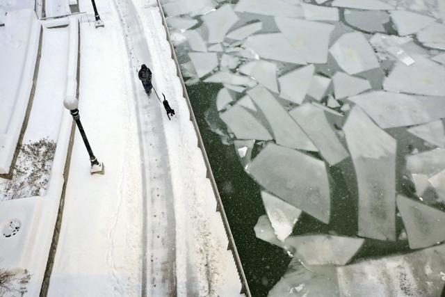 A dog walker passes beneath the DuSable Michigan Avenue Bridge next to a frozen Chicago River, Friday, Feb. 9, 2018 in Chicago. (AP) A dog walker passes beneath the DuSable Michigan Avenue Bridge next to a frozen Chicago River, Friday, Feb. 9, 2018 in Chicago. (AP)