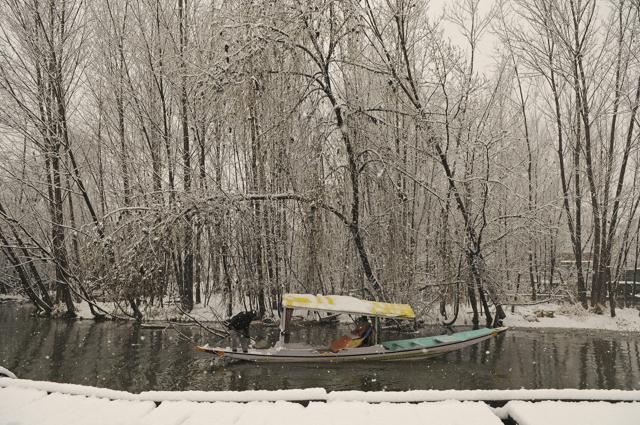 A Kashmiri boatman rows his boat as it snows on Monday. (Waseem Andrabi / HT Photo)