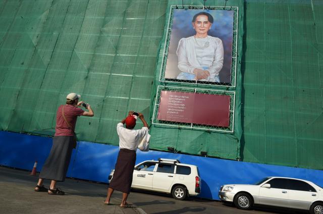 A tourist and local man take a photograph of a huge portrait of Myanmar's de facto leader Aung San Suu Kyi displayed on a building construction site overlooking Mahabandoola park in Yangon. (AFP File Photo) A tourist and local man take a photograph of a huge portrait of Myanmar's de facto leader Aung San Suu Kyi displayed on a building construction site overlooking Mahabandoola park in Yangon. (AFP File Photo)