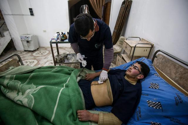 Malek Abu Jaber (below), a 20-year-old nurse, lies on a bed as a colleague changes his bandages at a makeshift clinic in the rebel-held town of Jisreen, in the besieged Eastern Ghouta region on the outskirts of the capital Damascus. (AFP Photo) Malek Abu Jaber (below), a 20-year-old nurse, lies on a bed as a colleague changes his bandages at a makeshift clinic in the rebel-held town of Jisreen, in the besieged Eastern Ghouta region on the outskirts of the capital Damascus. (AFP Photo)