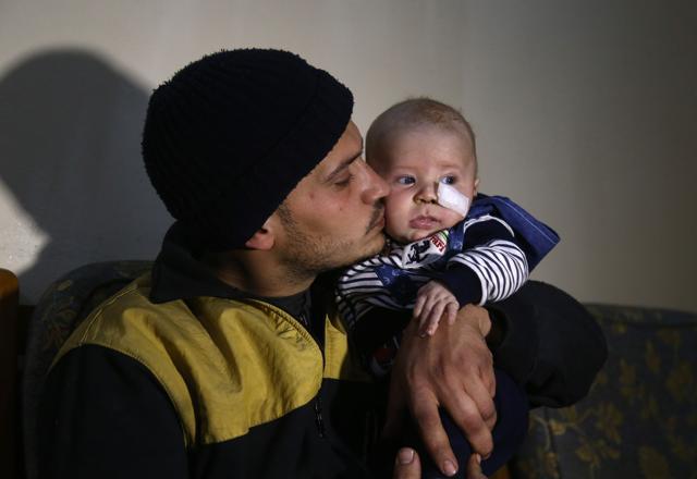 27-year-old member of the White Helmets rescue forces, Saeed al-Masri, holds his three-month-old son Yehya who he rescued after bombardment hit their home the previous week in Saqba in Syria's rebel-held Eastern Ghouta area on February 12, 2018. (AFP Photo) 27-year-old member of the White Helmets rescue forces, Saeed al-Masri, holds his three-month-old son Yehya who he rescued after bombardment hit their home the previous week in Saqba in Syria's rebel-held Eastern Ghouta area on February 12, 2018. (AFP Photo)