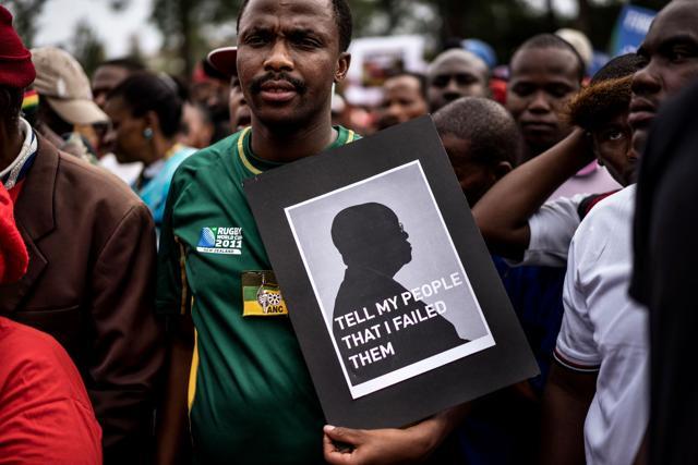A man holds a placard picturing South African president Jacob Zuma as he takes part in a demonstration with tens of thousands of opposition parties and civil society organisation members, in Pretoria. (AFP File Photo) A man holds a placard picturing South African president Jacob Zuma as he takes part in a demonstration with tens of thousands of opposition parties and civil society organisation members, in Pretoria. (AFP File Photo)