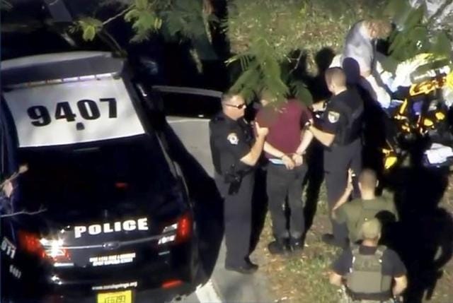 A man placed in handcuffs is led by police near Marjory Stoneman Douglas High School following a shooting incident in Parkland, Florida. (Reuters Photo) A man placed in handcuffs is led by police near Marjory Stoneman Douglas High School following a shooting incident in Parkland, Florida. (Reuters Photo)
