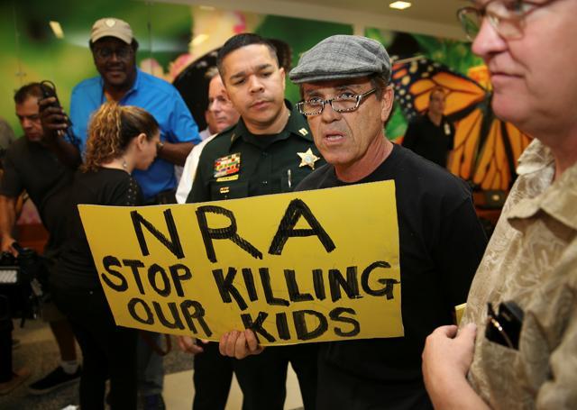 A man with a sign is seen after the news conference in the hallway outside the courtroom where Nikolas Cruz appeared via video at a bond court hearing, in Fort Lauderdale, Florida. (Reuters Photo) A man with a sign is seen after the news conference in the hallway outside the courtroom where Nikolas Cruz appeared via video at a bond court hearing, in Fort Lauderdale, Florida. (Reuters Photo)