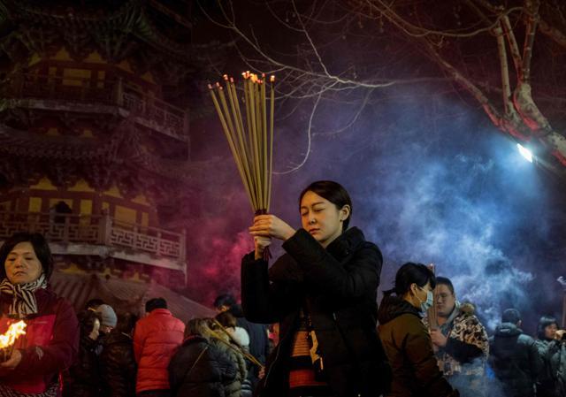 People pray with incense sticks to celebrate the Lunar New Year, marking the Year of the Dog, at the Longhua temple in Shanghai early February 16, 2018. (AFP Photo)