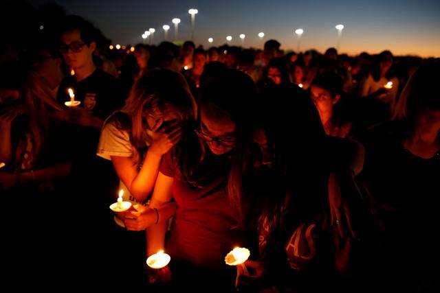 People attend a candlelight vigil for victims of shooting at nearby Marjory Stoneman Douglas High School, in Parkland, Florida, US. (Reuters photo) People attend a candlelight vigil for victims of shooting at nearby Marjory Stoneman Douglas High School, in Parkland, Florida, US. (Reuters photo)