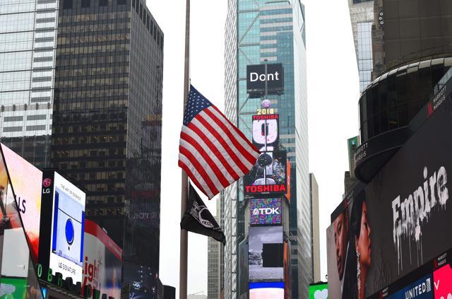 An American flag flies at half staff in Times Square on Thursday in New York following a school shooting in Florida on Wednesday. (AFP)