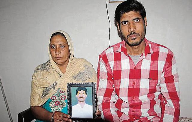Angoori Devi and her son holding photo of her late husband Krishna Saini. (HT Photo) Angoori Devi and her son holding photo of her late husband Krishna Saini. (HT Photo)