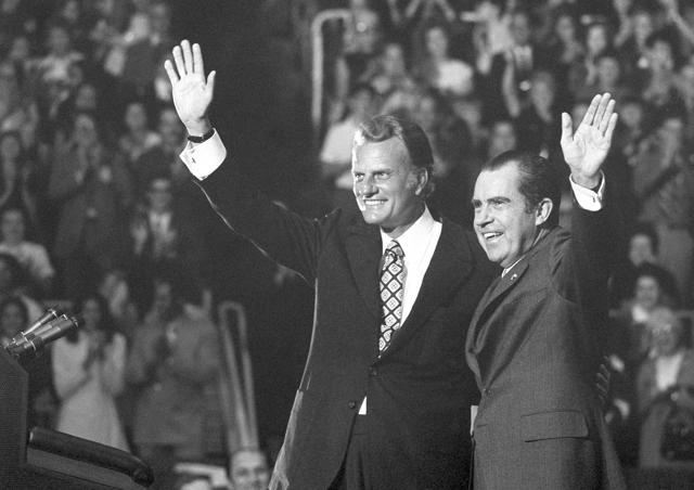 In this October 16, 1971 photo, Billy Graham and President Nixon wave to a crowd of 12,500 at ceremonies honouring Graham at Charlotte, N.C. Graham. (AP Archive)