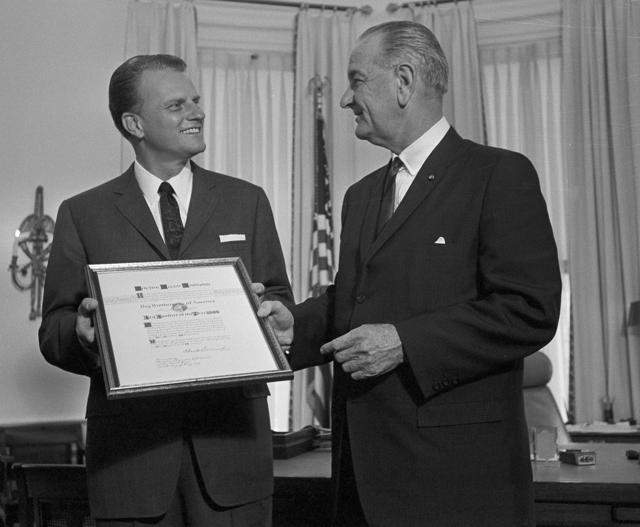 In this May 10, 1966 file photo, President Lyndon Johnson presents the Man of the Year award of the Big Brothers organization to evangelist Billy Graham at the White House in Washington. (AP Archive)