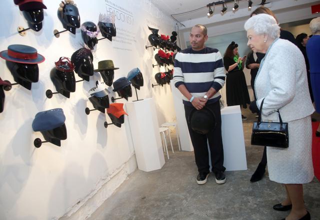 Queen Elizabeth II looks at a display during her visit at London Fashion Week. (REUTERS) Queen Elizabeth II looks at a display during her visit at London Fashion Week. (REUTERS)