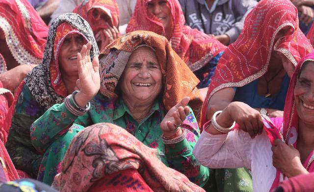 Farmers who were stopped from marching towards Jaipur, laugh at the jokes by speakers (not in the picture) as they block the highway at Reengus, in Sikar, on Thursday. (Himanshu Vyas/HT Photo)