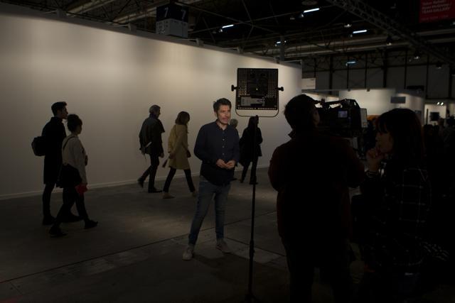 A television journalist reports in front of a blank white wall where art works by artist Santiago Sierra were hung before being taken down in a gallery on the first day of annual the ARCO International Art Fair. (AP)