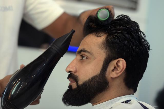 A male hairdresser blow-drying a customer's hair at a men's salon in Islamabad. (AFP)