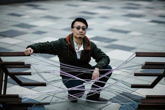 Local artist Ho Kwun Ting poses with his sculpture '[[x]]' at the Harbour Arts Sculpture Park. (AFP)
