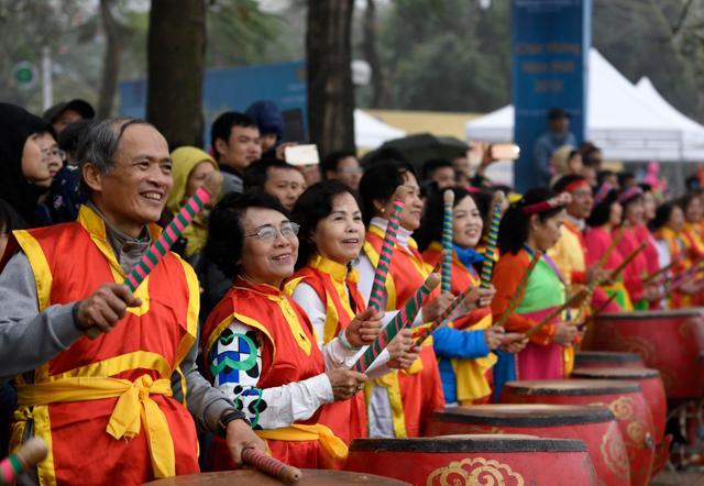 People play traditional drums as they cheer on participants during a dragon boat race in Hanoi. (AFP)