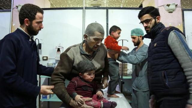 A Syrian man covered with dust from reported regime bombardment sits carrying a child as they are tended to by paramedics at a make-shift clinic in the rebel-held town of Douma, in the besieged Eastern Ghouta region on the outskirts of the capital Damascus, on February 24, 2018. (AFP Photo) A Syrian man covered with dust from reported regime bombardment sits carrying a child as they are tended to by paramedics at a make-shift clinic in the rebel-held town of Douma, in the besieged Eastern Ghouta region on the outskirts of the capital Damascus, on February 24, 2018. (AFP Photo)