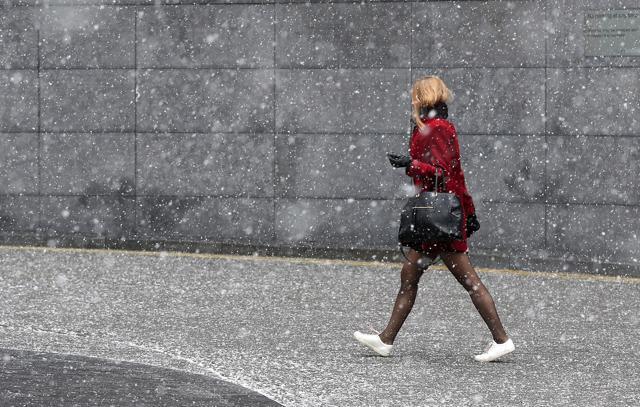 A woman walks near London Bridge as commuters make their way to work in heavy snow, London. (AP Photo) A woman walks near London Bridge as commuters make their way to work in heavy snow, London. (AP Photo)