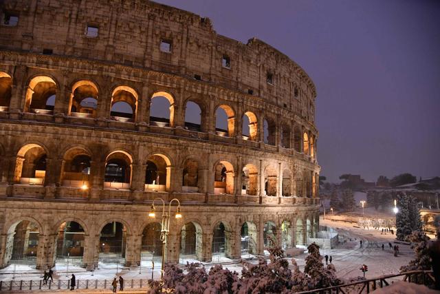 People walk in the snow near the Colosseum in Rome. (AFP Photo) People walk in the snow near the Colosseum in Rome. (AFP Photo)