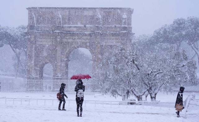 Tourists visit the Arch of Constantine during a snowfall in Rome. (AFP Photo) Tourists visit the Arch of Constantine during a snowfall in Rome. (AFP Photo)
