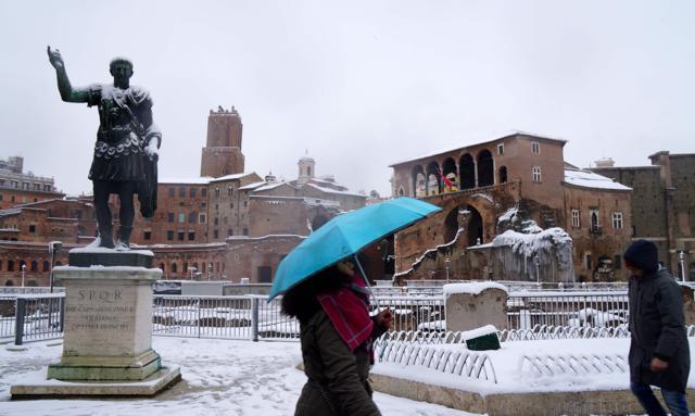 People walk in central via dei Fori during a snowfall in Rome. (AFP Photo) People walk in central via dei Fori during a snowfall in Rome. (AFP Photo)